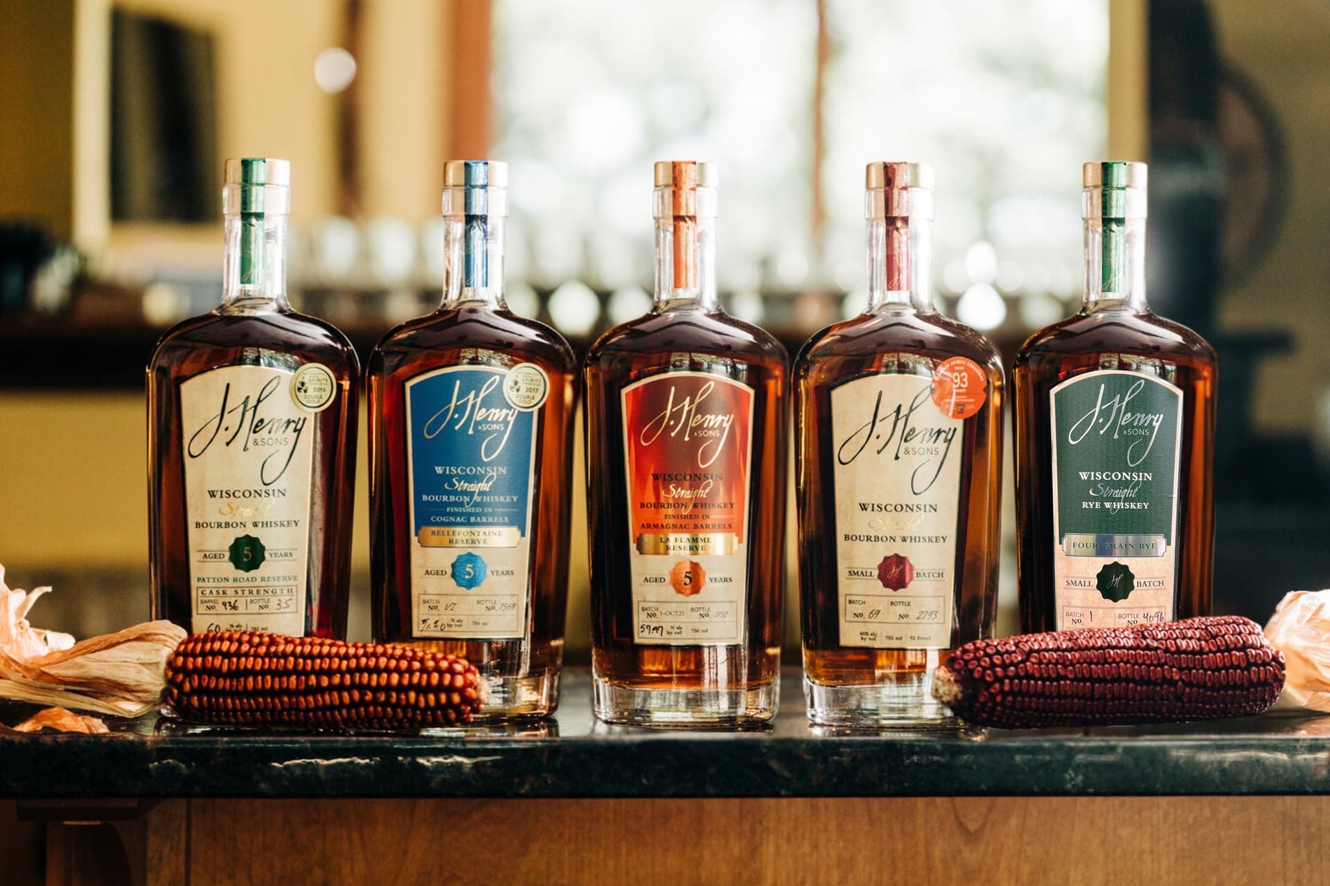 The J. Henry & Sons lineup with heirloom red corn — including the Four Grain Rye whiskey